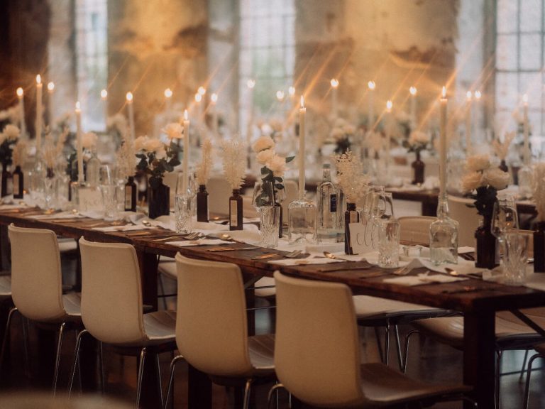 Tisch-Setting einer Hochzeit mit brennenden Kerzen