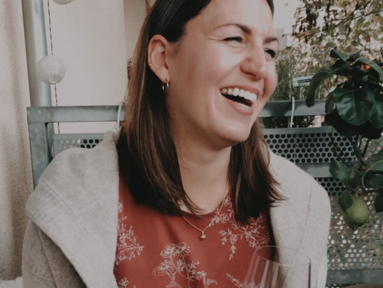 Irina, lachend mit einem Glas Wein